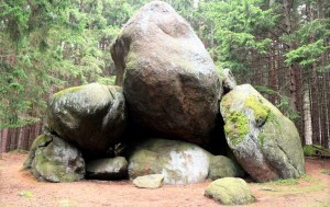 Large rock formation in the forest overgrown with moss