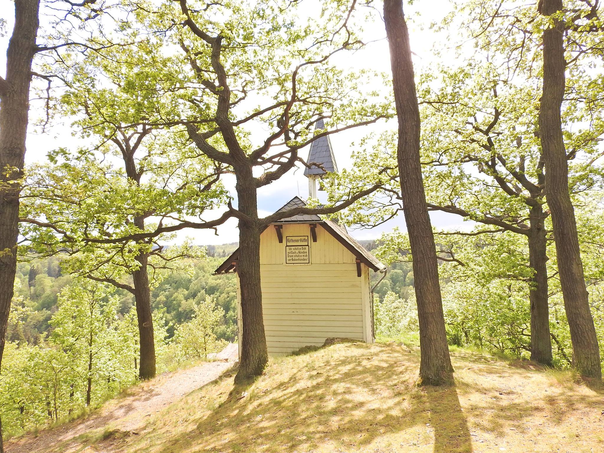 Small chapel in the forest on a sunny hill