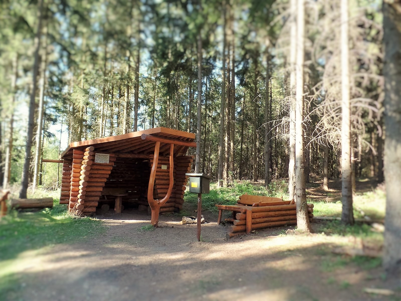 Holzhütte mit Sitzplatz im Wald