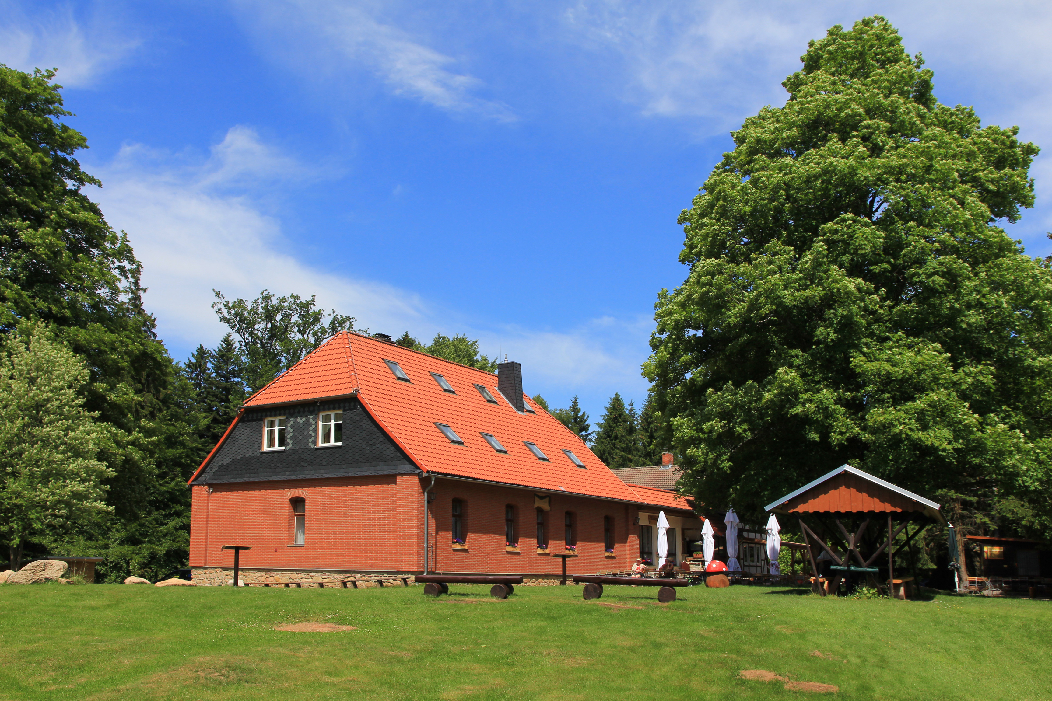 Backsteinhaus mit rotem Dach im Grünen
