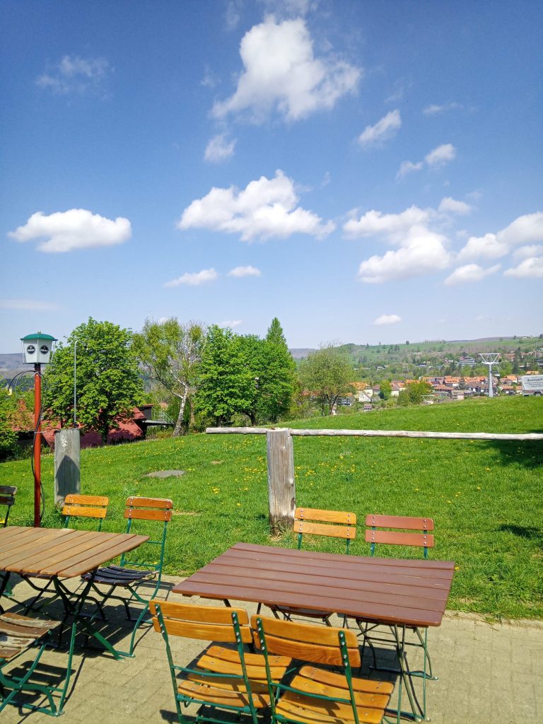 Biergarten mit Blick auf grüne Wiese und Dorf
